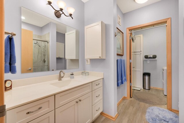 4100 Spring St Unit 310, Spring Park, MN 55384 - full bath with washing machine and dryer, a shower stall, vanity, and wood finished floors