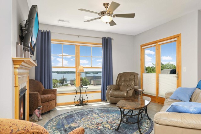 4100 Spring St Unit 310, Spring Park, MN 55384 - living area featuring wood finished floors, a lit fireplace, and a ceiling fan