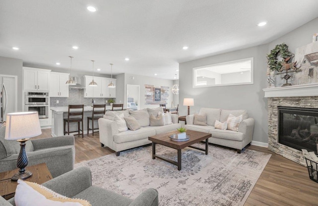 5201 Ramier Ave NE, Otsego, MN 55374 - living room featuring light wood-style flooring, a fireplace, recessed lighting, and baseboards