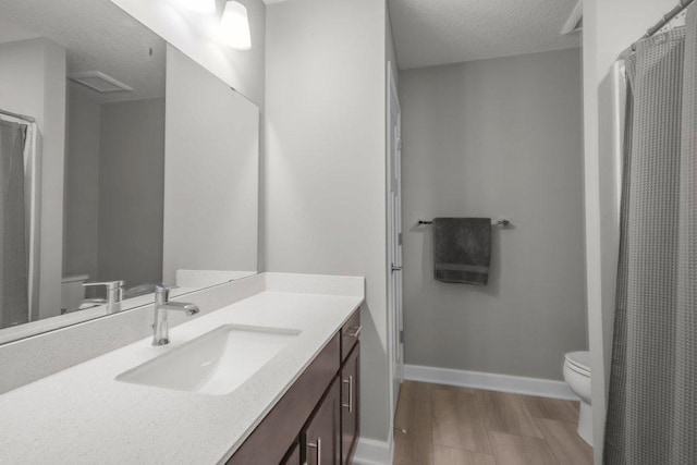 5201 Ramier Ave NE, Otsego, MN 55374 - bathroom with toilet, a textured ceiling, vanity, wood finished floors, and baseboards