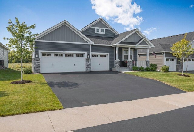 5201 Ramier Ave NE, Otsego, MN 55374 - craftsman-style home featuring board and batten siding, a porch, a front yard, and an attached garage