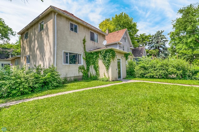 1002 10th St N, Fargo, ND 58102 - view of property exterior with stucco siding and a lawn