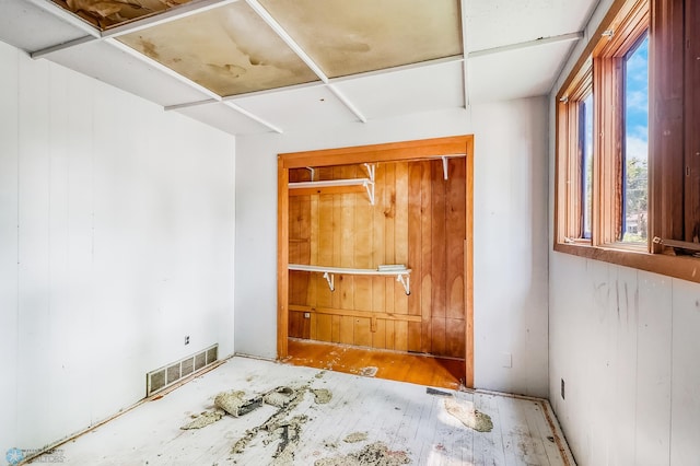 1002 10th St N, Fargo, ND 58102 - unfurnished bedroom featuring multiple windows, wood finished floors, and wooden walls
