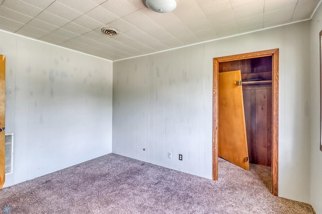 1002 10th St N, Fargo, ND 58102 - unfurnished bedroom featuring carpet floors, a closet, and wood walls