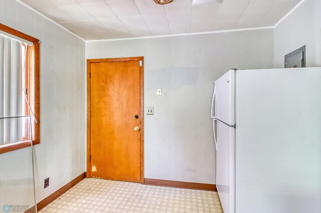 1002 10th St N, Fargo, ND 58102 - kitchen featuring freestanding refrigerator, ornamental molding, tile patterned floors, and wooden walls