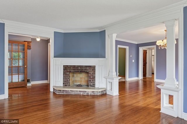76 Western Ave N, Saint Paul, MN 55102 - unfurnished living room featuring wood finished floors, a fireplace, crown molding, ornate columns, and a chandelier