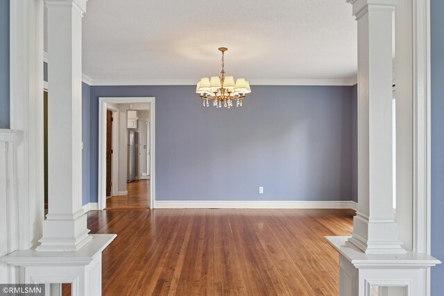 76 Western Ave N, Saint Paul, MN 55102 - spare room featuring wood finished floors, a chandelier, ornate columns, and ornamental molding