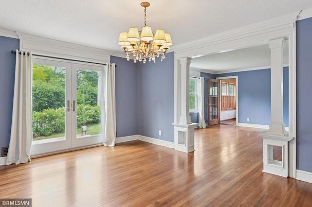 76 Western Ave N, Saint Paul, MN 55102 - unfurnished room featuring ornate columns, healthy amount of natural light, wood finished floors, crown molding, and a chandelier