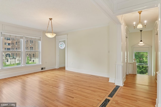 76 Western Ave N, Saint Paul, MN 55102 - unfurnished dining area featuring light wood finished floors, ornate columns, and crown molding