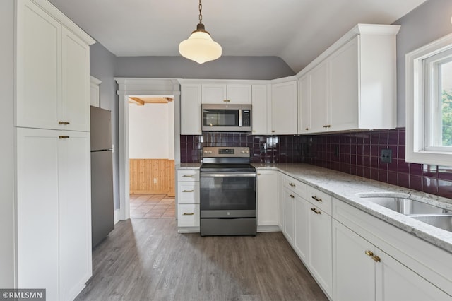 76 Western Ave N, Saint Paul, MN 55102 - kitchen with appliances with stainless steel finishes, white cabinetry, wood finished floors, and lofted ceiling