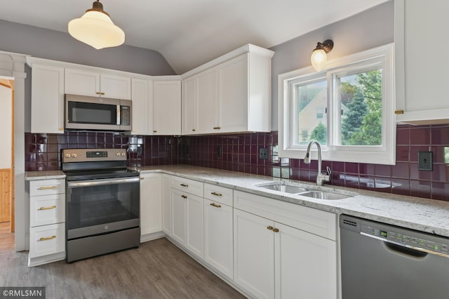 76 Western Ave N, Saint Paul, MN 55102 - kitchen featuring appliances with stainless steel finishes, white cabinets, wood finished floors, lofted ceiling, and decorative backsplash