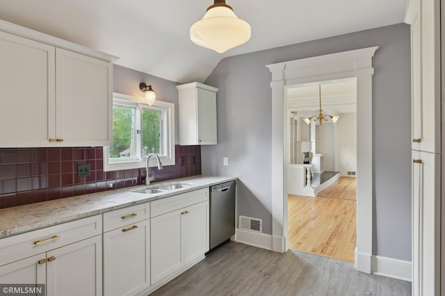 76 Western Ave N, Saint Paul, MN 55102 - kitchen featuring stainless steel dishwasher, backsplash, white cabinets, light wood-style floors, and vaulted ceiling