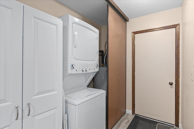 7079 Robinwood Trl, Woodbury, MN 55125 - laundry area with stacked washer / drying machine and a textured ceiling