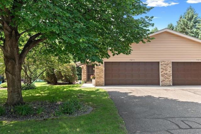 7079 Robinwood Trl, Woodbury, MN 55125 - obstructed view of property featuring brick siding and a front yard