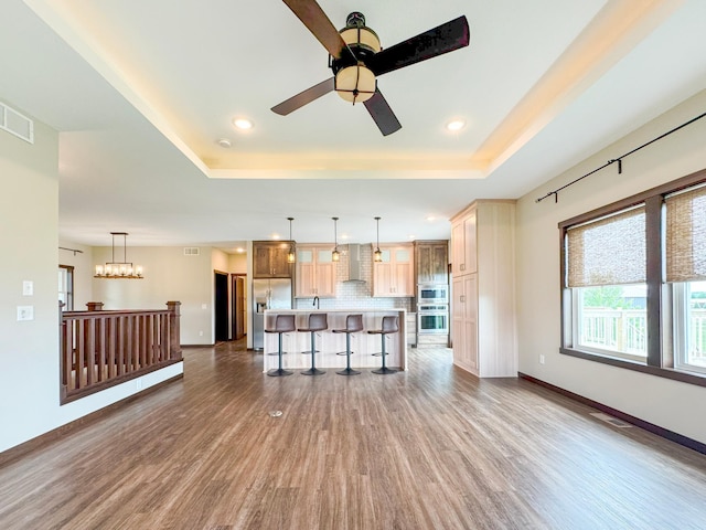 39847 447th St, Sauk Centre Twp, MN 56378 - unfurnished living room with wood finished floors, a tray ceiling, a ceiling fan, baseboards, and recessed lighting