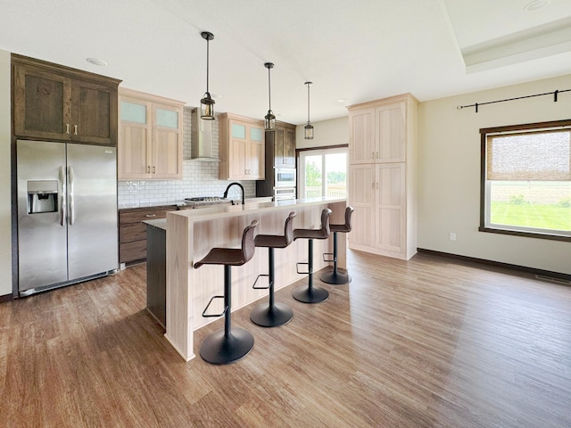 39847 447th St, Sauk Centre Twp, MN 56378 - kitchen featuring stainless steel refrigerator with ice dispenser, dark wood-style floors, wall chimney exhaust hood, a kitchen breakfast bar, and tasteful backsplash