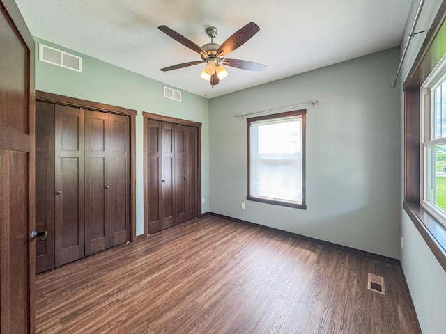 39847 447th St, Sauk Centre Twp, MN 56378 - unfurnished bedroom with multiple closets, wood finished floors, and multiple windows