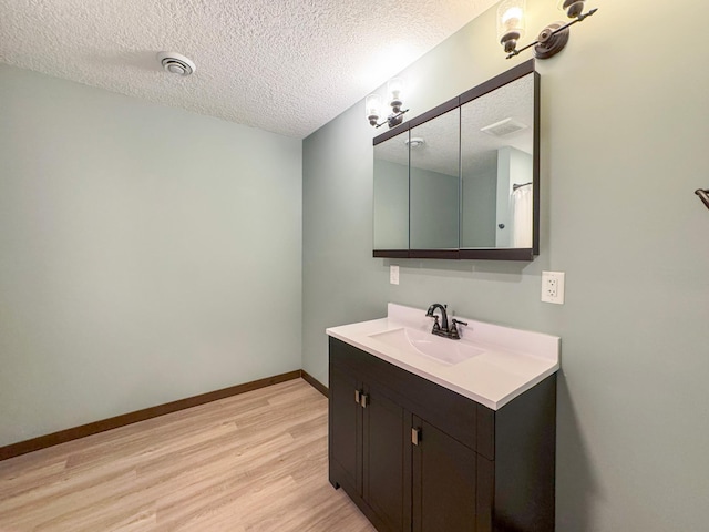 39847 447th St, Sauk Centre Twp, MN 56378 - full bathroom with wood finished floors, vanity, a textured ceiling, and baseboards