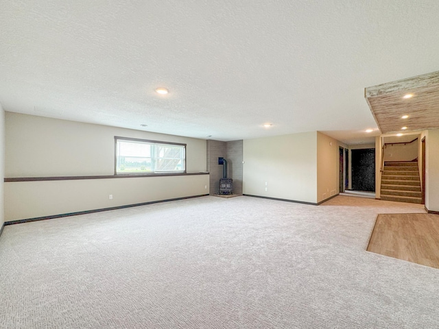 39847 447th St, Sauk Centre Twp, MN 56378 - carpeted empty room with stairs, recessed lighting, baseboards, a wood stove, and a textured ceiling