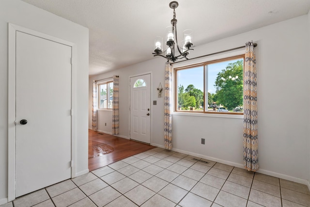 2452 Parkview Ln SE, Rochester, MN 55904 - entrance foyer with a chandelier, baseboards, and light tile patterned flooring