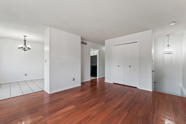 2452 Parkview Ln SE, Rochester, MN 55904 - unfurnished living room featuring a chandelier, wood finished floors, and baseboards