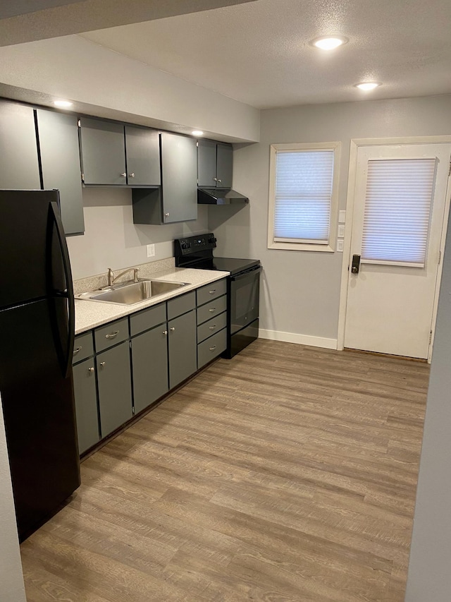 411 Broadway St, Redwood Falls, MN 56283 - kitchen featuring black appliances, under cabinet range hood, light wood-type flooring, gray cabinets, and a textured ceiling