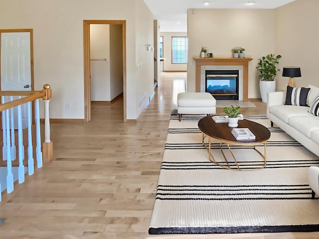 15579 June Grass Ln, Eden Prairie, MN 55347 - living area featuring baseboards, light wood-type flooring, and a fireplace with flush hearth