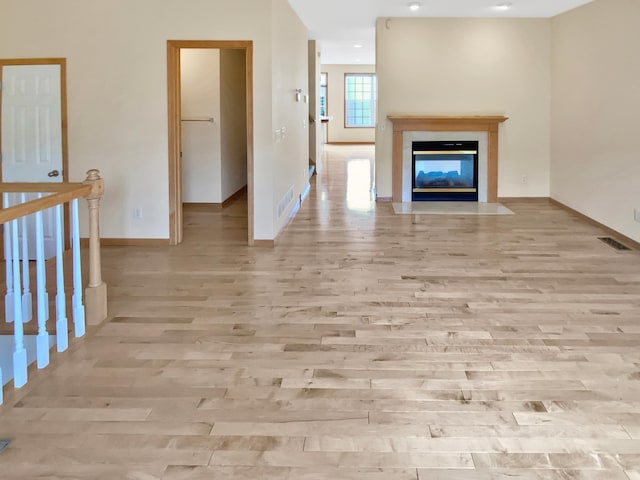 15579 June Grass Ln, Eden Prairie, MN 55347 - unfurnished living room featuring wood finished floors, baseboards, and a fireplace with flush hearth