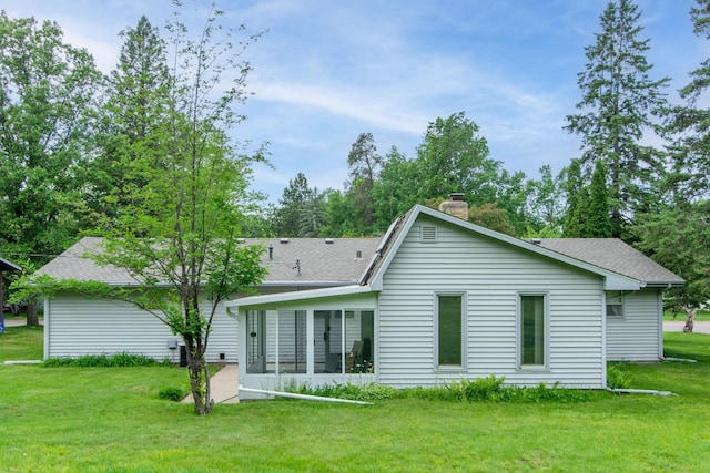 2103 Graydon Ave, Brainerd, MN 56401 - rear view of house with a chimney, a shingled roof, a lawn, and a sunroom