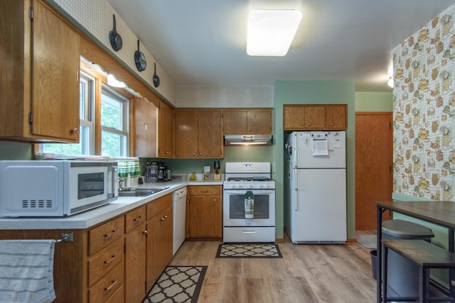 2103 Graydon Ave, Brainerd, MN 56401 - kitchen with white appliances, under cabinet range hood, light countertops, light wood finished floors, and brown cabinets