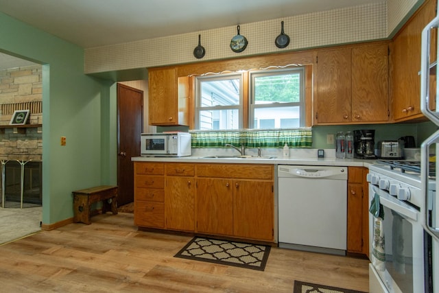 2103 Graydon Ave, Brainerd, MN 56401 - kitchen featuring white appliances, a sink, light countertops, light wood-type flooring, and a fireplace