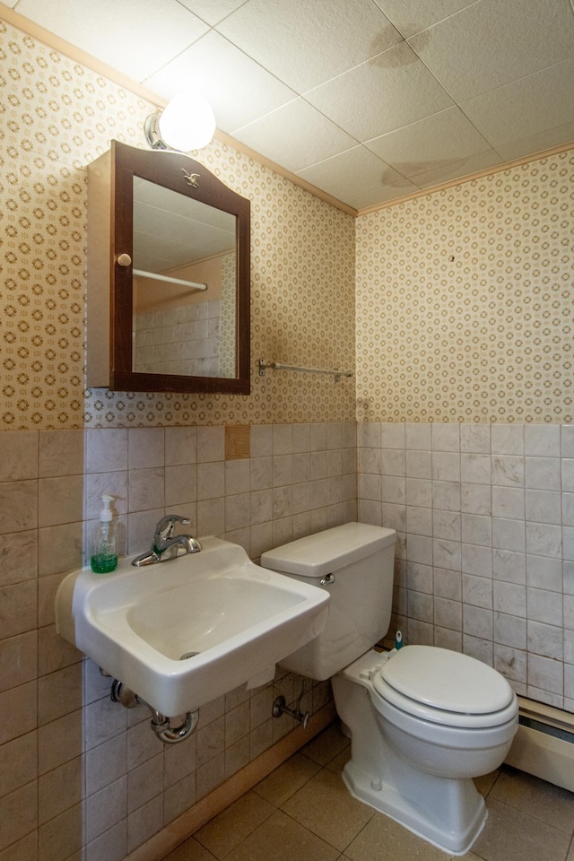 2103 Graydon Ave, Brainerd, MN 56401 - bathroom featuring toilet, tile walls, a sink, wallpapered walls, and tile patterned floors