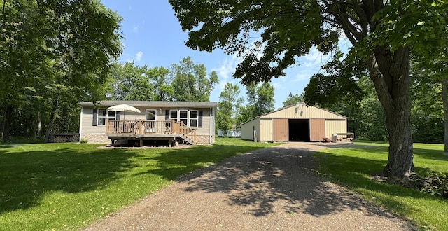 38634 241st St, Aitkin, MN 56431 - view of front of house with a pole building, a front yard, a deck, and an outdoor structure