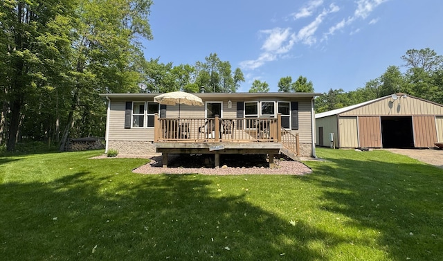38634 241st St, Aitkin, MN 56431 - back of property with a garage, a wooden deck, a yard, and an outbuilding