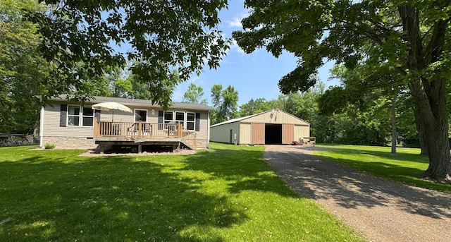 38634 241st St, Aitkin, MN 56431 - view of front of property featuring a wooden deck, a detached garage, a front yard, and an outbuilding