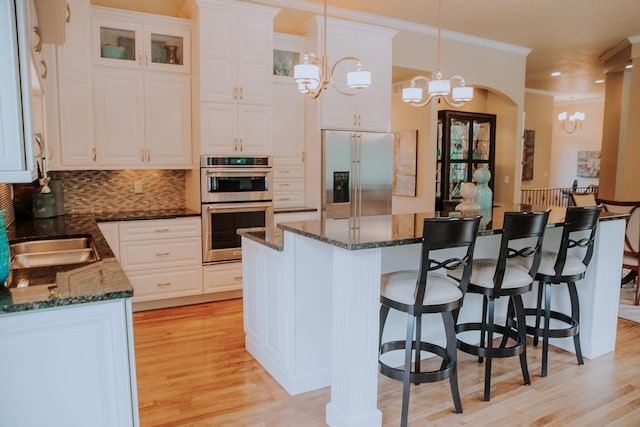 1509 Haller Ct S, Maplewood, MN 55119 - kitchen with stainless steel appliances, a chandelier, a breakfast bar area, crown molding, and white cabinets