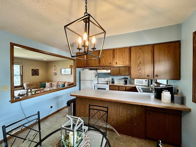 1922 13th Ave N, Moorhead, MN 56560 - kitchen with white appliances, brown cabinetry, a peninsula, extractor fan, and light countertops