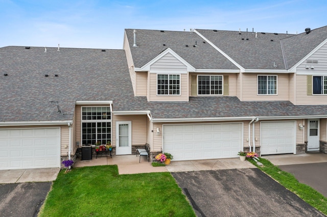 315 Roosevelt St S Unit B, Cambridge, MN 55008 - view of property with stone siding, roof with shingles, driveway, a front lawn, and an attached garage