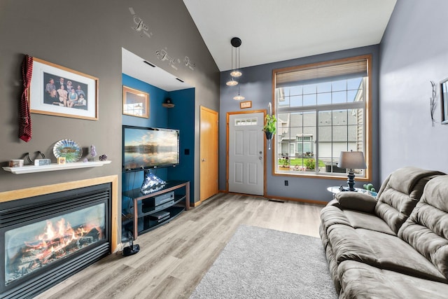315 Roosevelt St S Unit B, Cambridge, MN 55008 - living room with wood finished floors, lofted ceiling, a glass covered fireplace, and baseboards