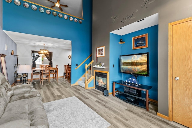 315 Roosevelt St S Unit B, Cambridge, MN 55008 - living room with wood finished floors, ceiling fan, baseboards, a towering ceiling, and stairway