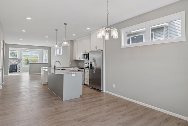 1250 Naser Way, New Richmond, WI 54017 - kitchen featuring appliances with stainless steel finishes, recessed lighting, white cabinetry, light wood finished floors, and an island with sink