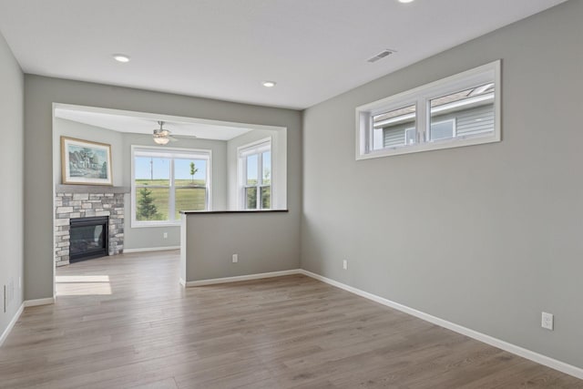 1250 Naser Way, New Richmond, WI 54017 - unfurnished living room featuring wood finished floors, a ceiling fan, a stone fireplace, and recessed lighting