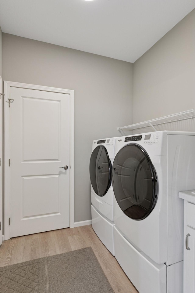 1250 Naser Way, New Richmond, WI 54017 - laundry room featuring separate washer and dryer, light wood-style floors, and cabinet space