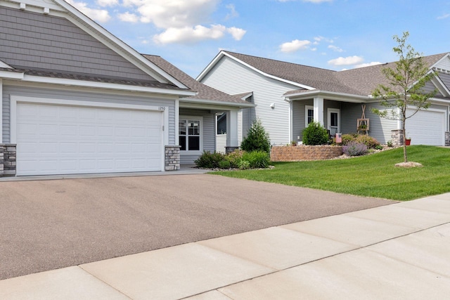 1250 Naser Way, New Richmond, WI 54017 - view of front of home featuring a front yard, driveway, stone siding, a garage, and a shingled roof