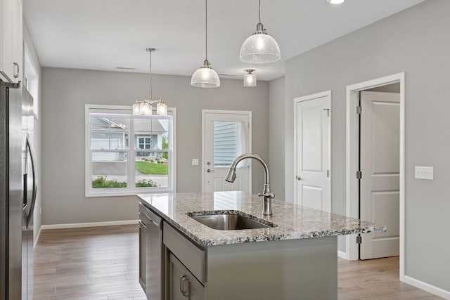 1250 Naser Way, New Richmond, WI 54017 - kitchen featuring stainless steel appliances, light wood-style floors, light stone countertops, an island with sink, and pendant lighting