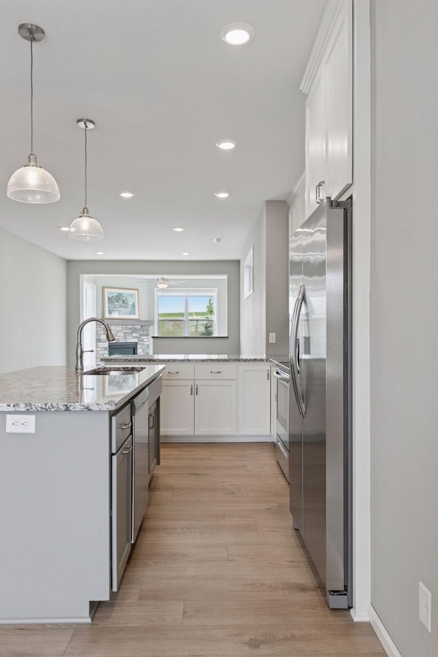 1250 Naser Way, New Richmond, WI 54017 - kitchen featuring stainless steel appliances, light wood-style floors, white cabinets, light stone countertops, and recessed lighting