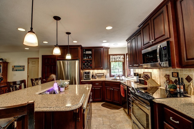 305 Birch Briar Ln, Park Rapids, MN 56470 - kitchen with stainless steel appliances, recessed lighting, decorative backsplash, a breakfast bar area, and light stone finish flooring