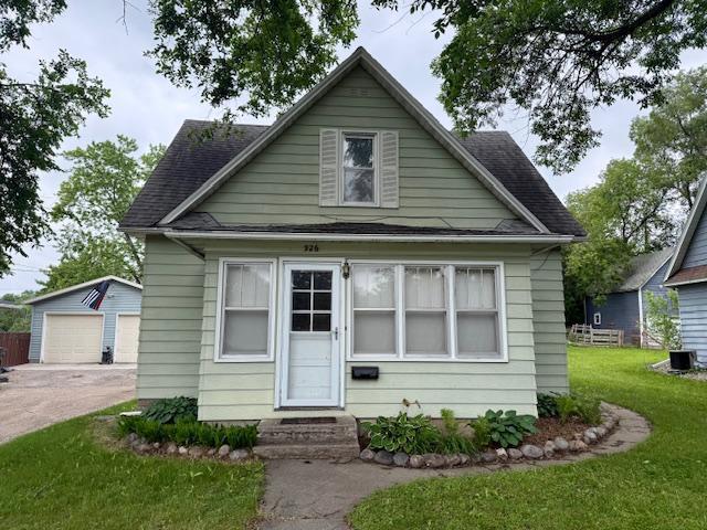926 Park St, Fergus Falls, MN 56537 - bungalow-style house featuring entry steps, an outbuilding, a detached garage, a front lawn, and a shingled roof