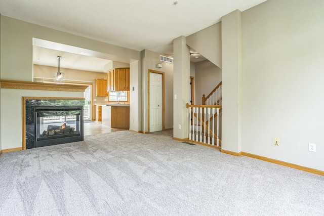 8812 Brunswick Path, Inver Grove Heights, MN 55076 - unfurnished living room with light carpet, a multi sided fireplace, and stairs