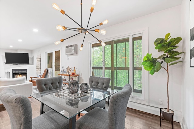 3850 Plymouth Blvd Unit 212, Plymouth, MN 55446 - dining space featuring wood finished floors, a chandelier, a wall mounted AC, a lit fireplace, and recessed lighting